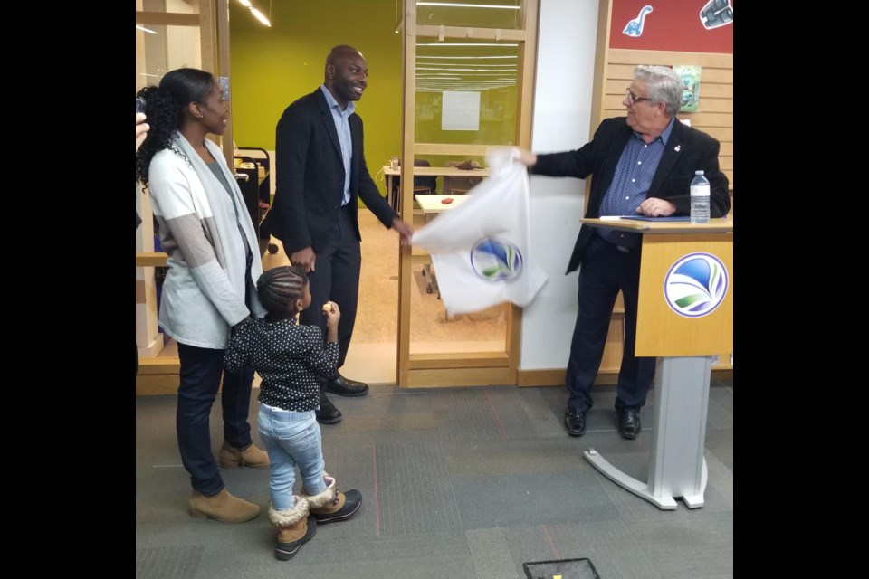 The Jamal Pascall Programming Room was recently dedicated at the Bradford West Gwillimbury Public Library. Here, Pascall, centre, and Mayor James Leduc unveil the room's name plaque. 