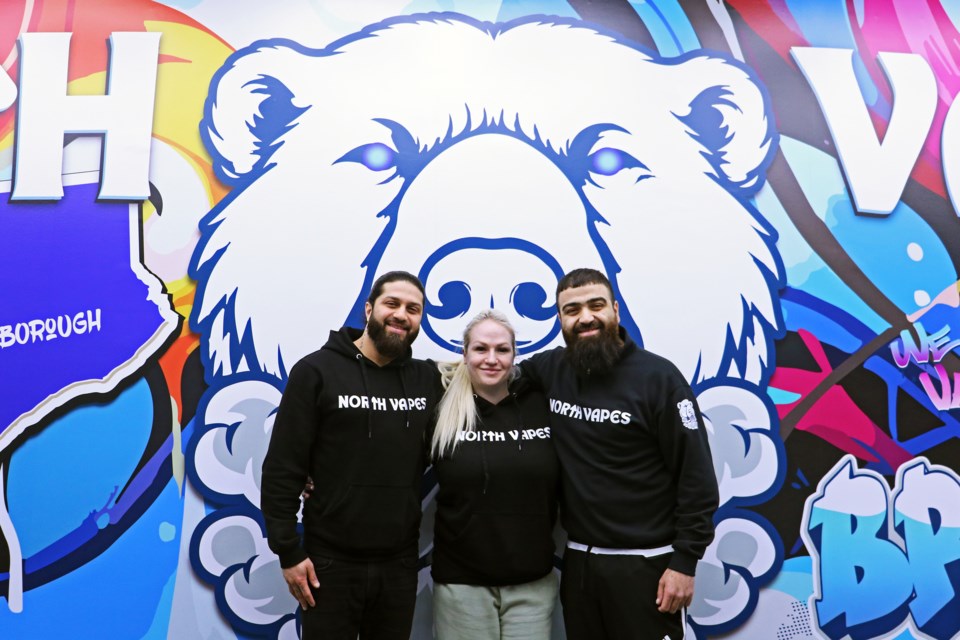 From left, Ali, Olivia and Mustafa Sarwary stand by the full-wall mural in their new shop, North Vapes, in Unit 2 at 136 Holland St. E. in Bradford, on Tuesday, April 16.