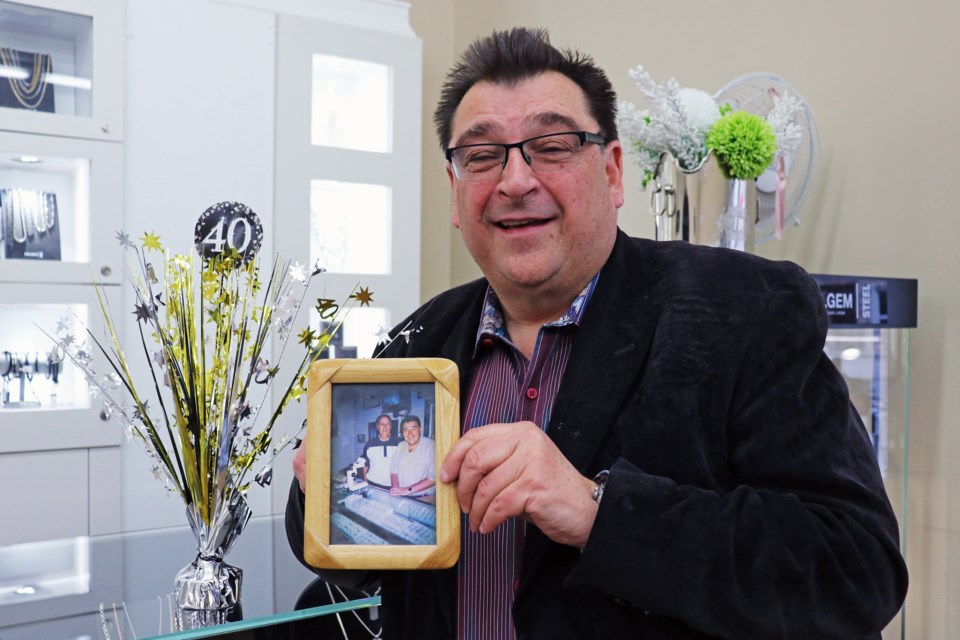 Long-time councillor and local business owner, Peter Dykie holds a photo of himself with his uncle on his mother’s side, who helped him get a mortgage for his store, inside the current storefront at 9 Holland St. E.