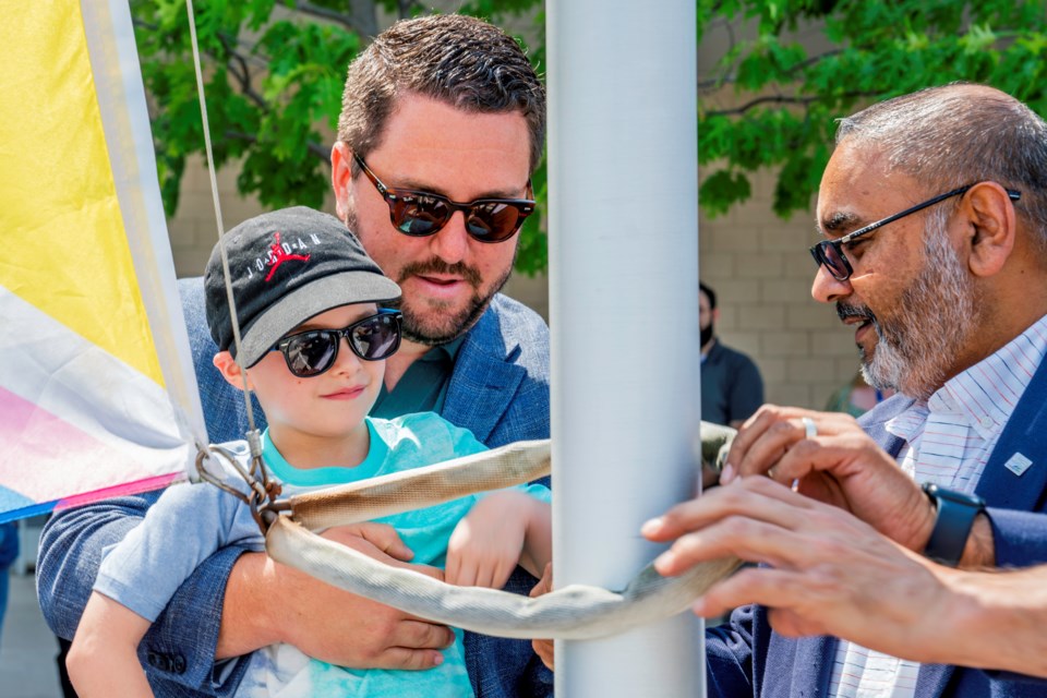 Young Emerson Simoes helps raise the flag to recognize June as Pride Month, which is dedicated to the celebration of the 2SLGBTQI+ community and culture, in support of 2SLGBTQI+ rights. The flag raising was held Friday afternoon.