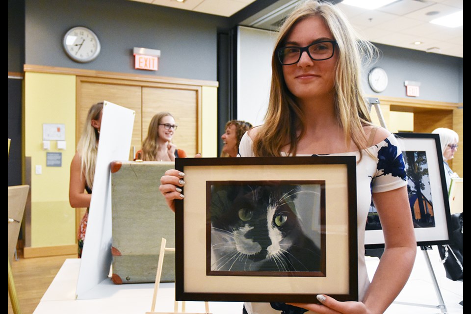 Young artist specializing in pet portraits, Brianna Boughner – with a portrait of Sammy, her cat. Miriam King/BradfordToday