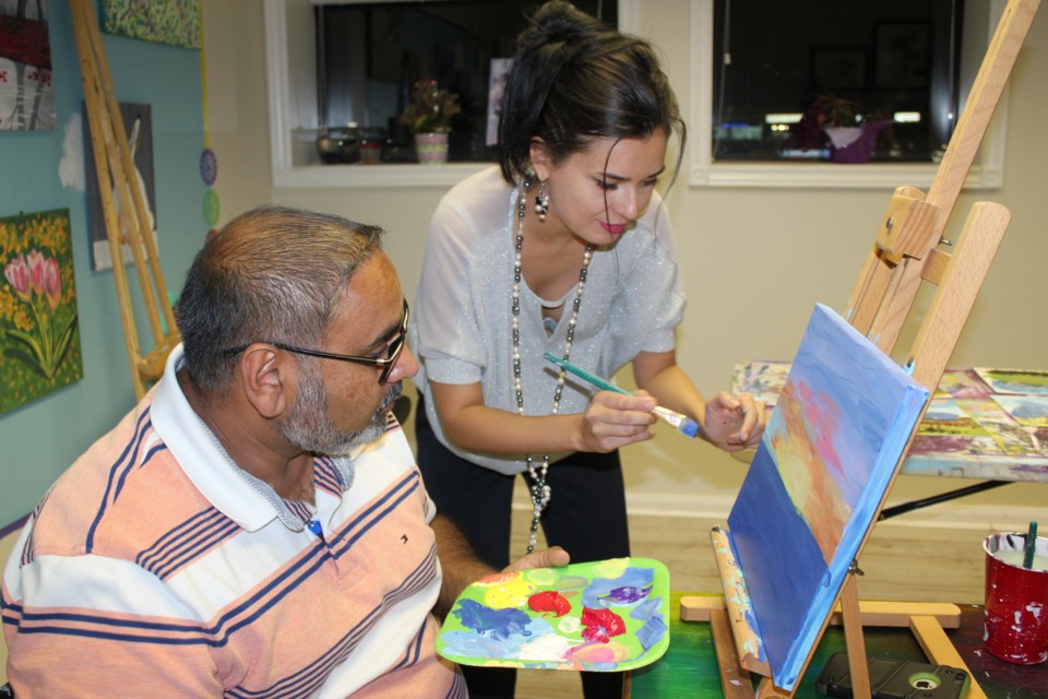 Coun. Raj Sandhu and Universal Learning Academy art teacher Daria Iezhachenko work together on a masterpiece. Submitted photo 