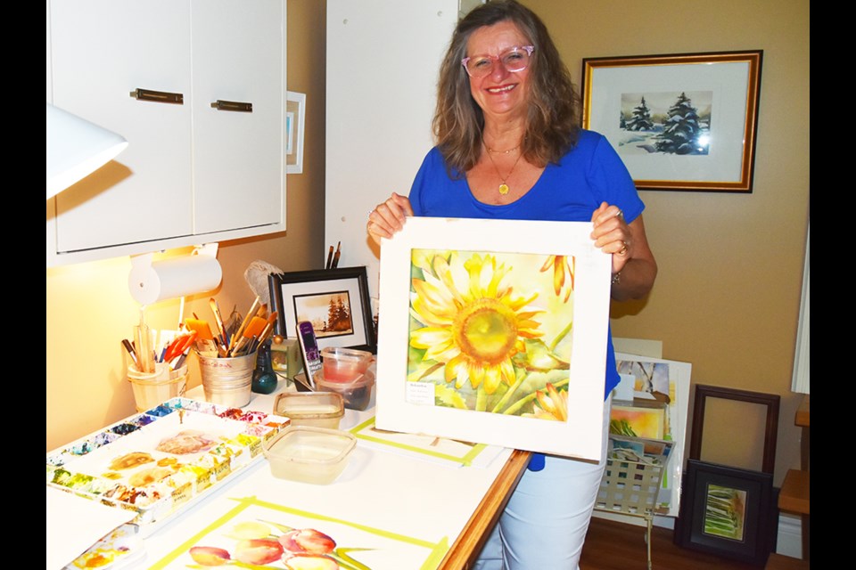 Angie Horsley, in her home studio, with floral watercolour. Miriam King/Bradford Today