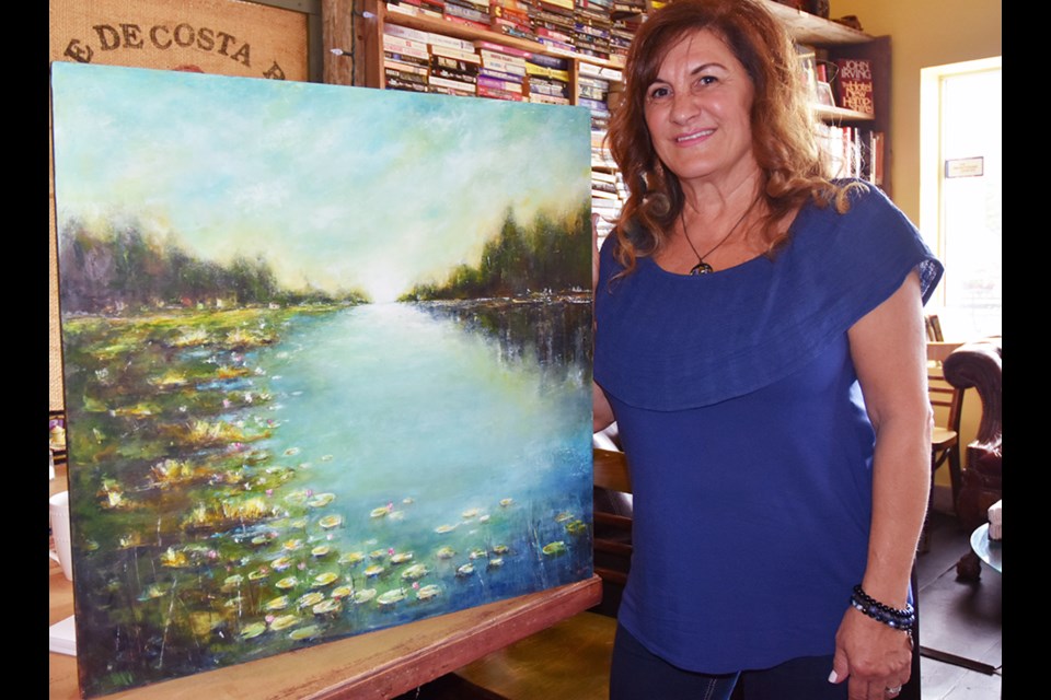 Artist Sylva Sroujian with oil and cold wax painting, 'Tranquil.' Miriam King/Bradford Today