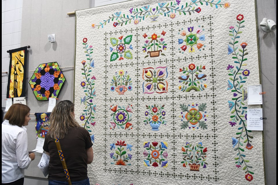 Taking a look at the quilt Reminiscence, designed by Jenny Griffiths and quilted by Ruth Quinn, at the Simcoe County Museum. Miriam King/Bradford Today