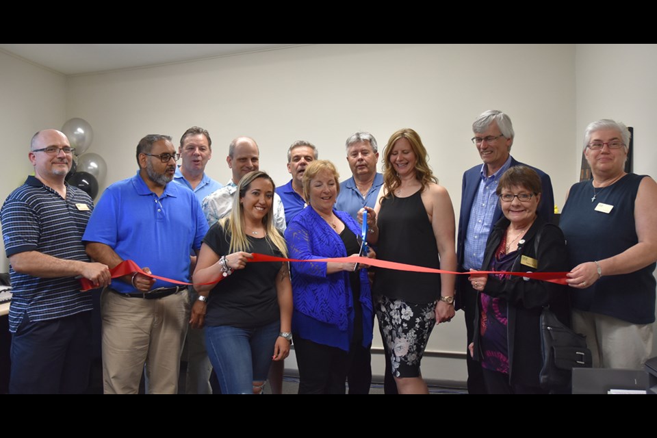 Denise Wiscombe and Shannon Maxwell cut the ribbon at the opening of the ICD Insurance Brokers office in Bradford, accompanied by Mayor Rob Keffer, Deputy Mayor James Leduc, councillors Raj Sandhu and Ron Orr, and members of the Bradford Board of Trade, on which Wiscombe has served. Miriam King/Bradford Today