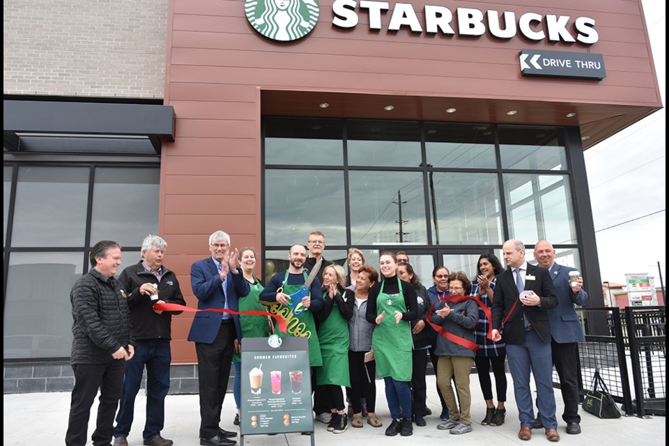 Staff, customers, Mayor and Councillors cut the red ribbon, officially opening Bradford West Starbucks on May 22. Miriam King/Bradford Today