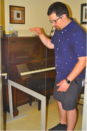 Owner Tyler Tossounian shows off his new custom-made plexiglass barriers built to keep both instructor and students safe during in-house lessons at the Bradford Academy of Music. Jackie Kozak/BradfordToday