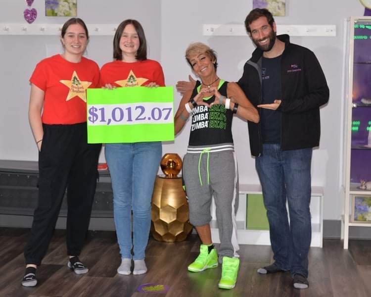 Sarah and Emily Dahlgren of A Bradford Christmas and Mark Snaper of Eye Candy Ads present Cathy McLean with a cheque from local fundraising campaigns to keep her Zumba studio open