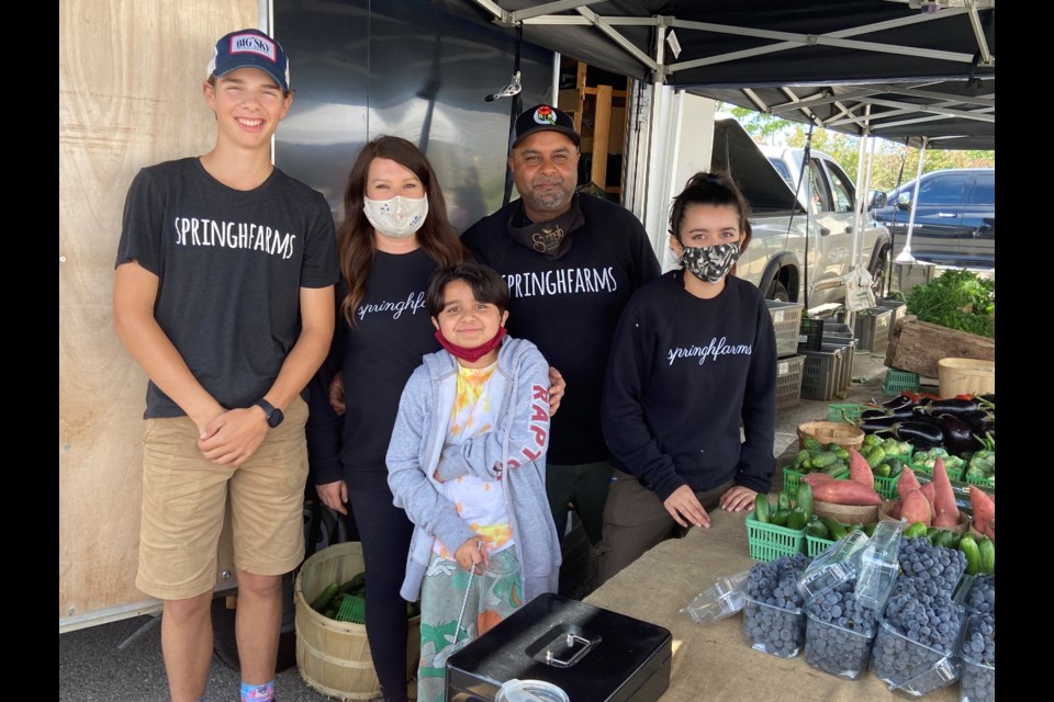 Shane Singh and his family at their booth selling delicious, fresh produce.