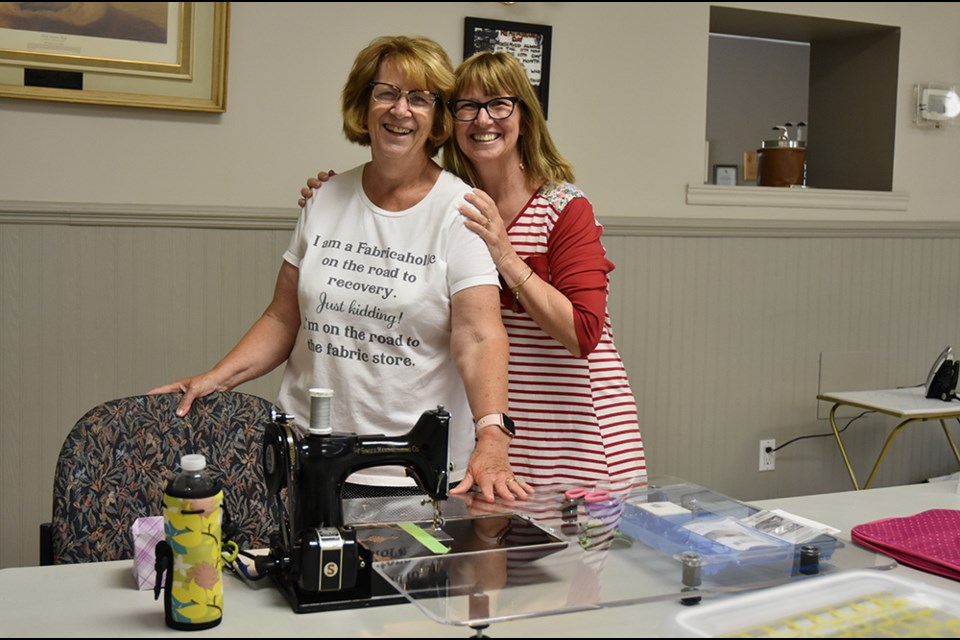 Sisters Lori Korstanje, right, and Jill Beisher meet at the quilting retreat in Bradford. Lori came all the way from Cambridge, Jill from Utopia, to work on their quilts together. Miriam King/BradfordToday
