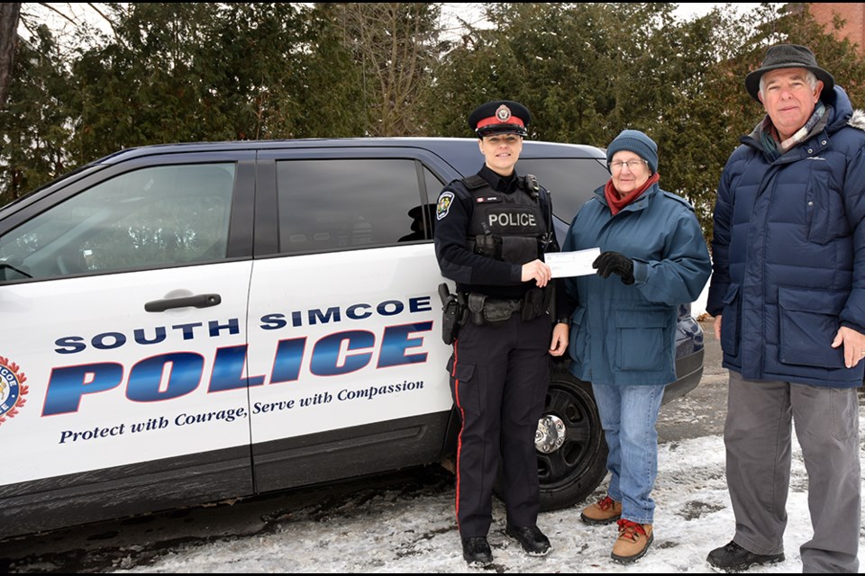 From left, South Simcoe Police constable Nicole Kostiuk presents the cash collected at this year’s Copper Cup to Food Bank president Anne Silvey and treasurer Alvin Belanger – a whopping $1191.57. Miriam King/BradfordToday