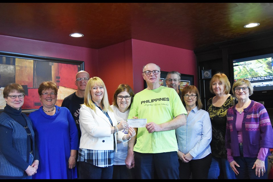 Surrounded by retired teachers, RTO District 17 president Carole Allen presents a grant to Jean and Tim McNair (centre), at Coffee Culture cafe in Bradford. Miriam King/Bradford Today