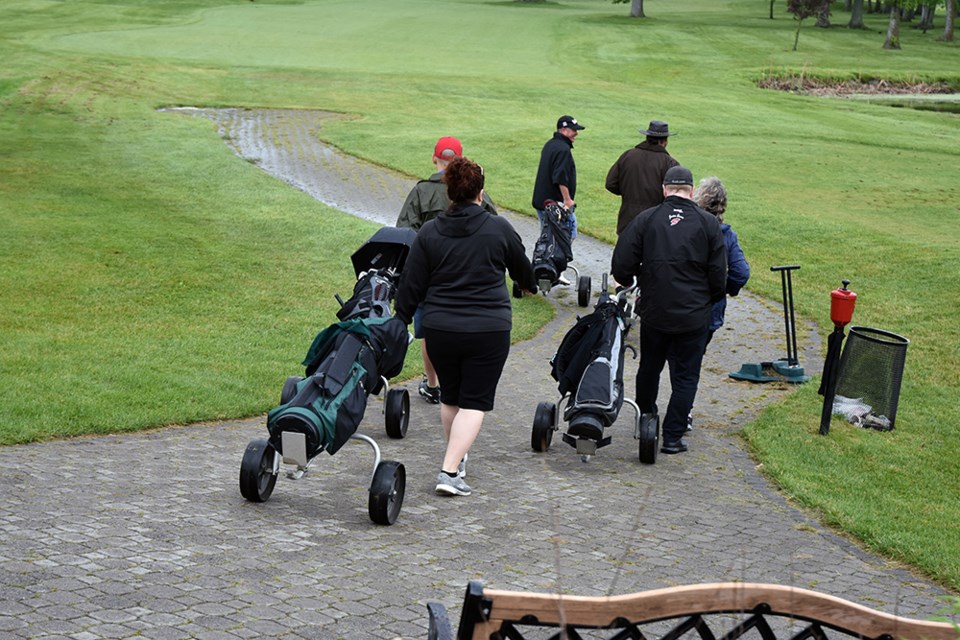 Some golfers used golf carts; others walked to their holes. Due to ground conditions, organizers split up golfers in carts and those on foot, and had them play the same 9 holes twice. Miriam King/Bradford Today