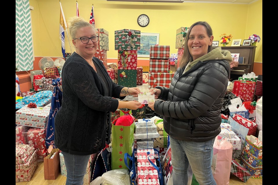 Cassidy Hilliard of Hillside Photography drops off the money she raised through her Christmas photo shoots to Patti LaRose at Out of the Cold Cafe for their Adopt-a-Family Christmas Wishlist program.
