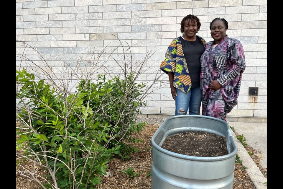 Nadia Sinclair, left, is shown with her friend, Omolara Akerele, in the garden at the Bradford West Gwillimbury Public Library.
