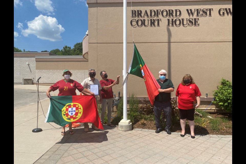 Ceu Perdiz, Deputy Mayor James Leduc, Paoulo Perdiz, Coun. Gary Lamb and Elizabeth Lambert raise the flag raised for Portugal Day 2021. 