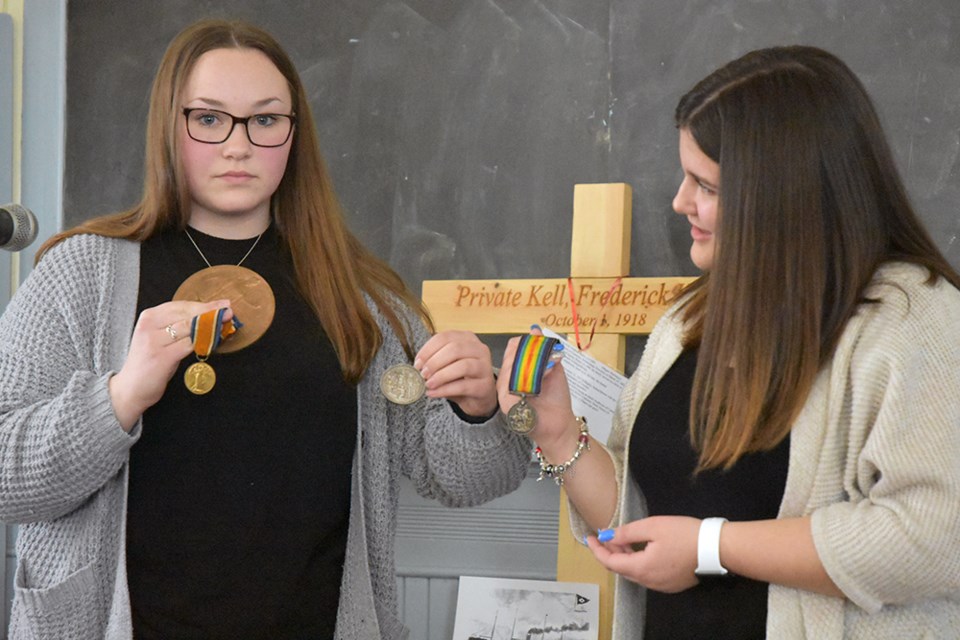 Nantyr Shores students Grace Morgan, left, and Sydney Robinson, with medals, 'Death Penny' of Morgan's Great Great Grandfather, George Mowforth. Miriam King/Bradford Today