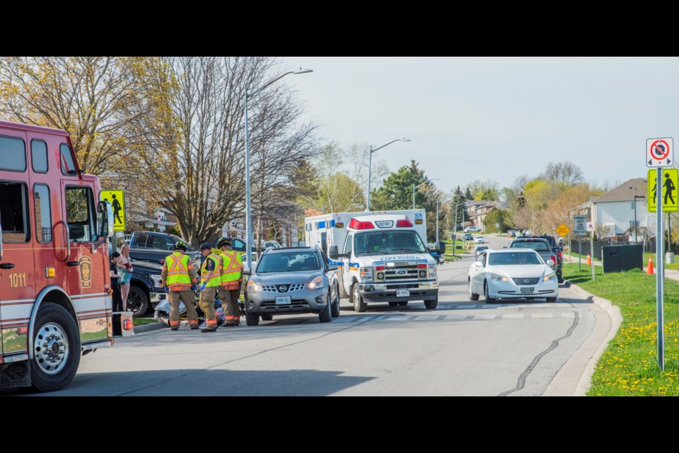 Emergency crews attend to a girl who was struck by a vehicle Tuesday on Colborne Street in Bradford.
