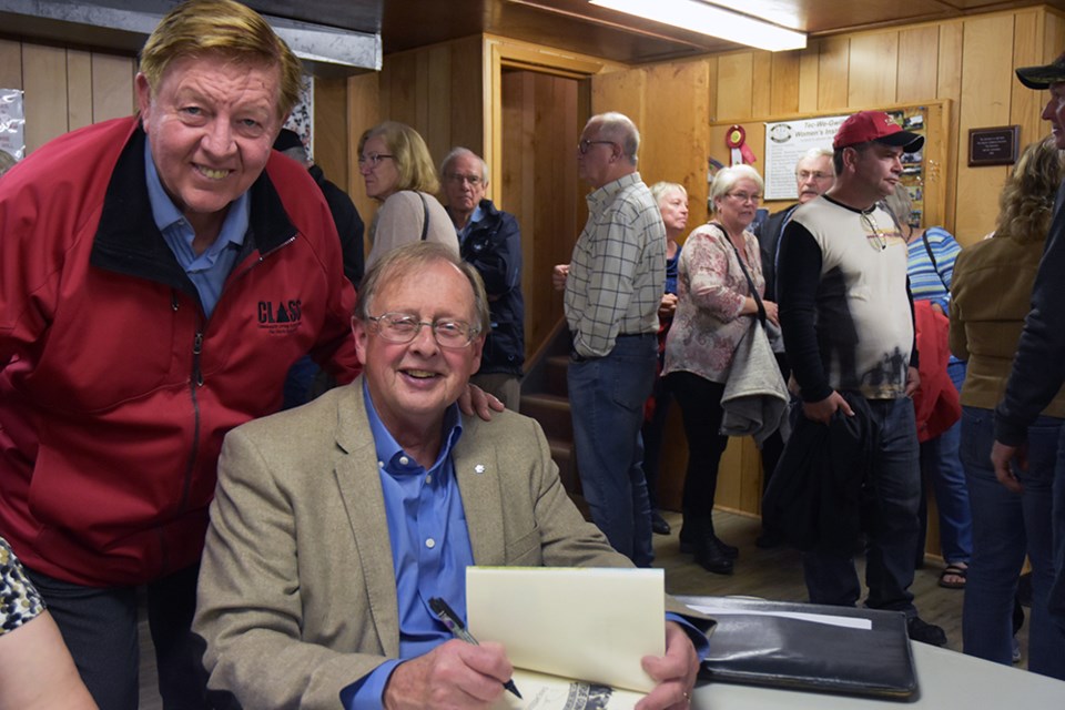 Author Dan Needles signs his book True Confessions from the Ninth Concession, for New Tecumseth Mayor Rick Milne. Miriam King/Bradford Today