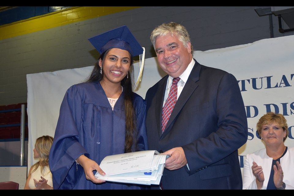 MP for York Simcoe Peter Van Loan presents the Lieutenant Governor’s Community Volunteer Award to Gurleen Athwal at the graduation ceremony for Bradford District High School, June 28. Athwal received numerous awards, including the Royal Canadian Legion Award for physics, Bradford Jewellery and Gems Award for school spirit, Danube Seniors Leisure Centre award, Kristen Coombes Memorial Award, Dr. Susan Kuzmyk Award for outstanding achievement in three Grade 12 university science courses, Principal’s Award for exemplary student leadership, Masonic Award in Memory of Charles Watson for highest standing in biology, and Frank Caietta chemistry award. Miriam King/Bradford Today