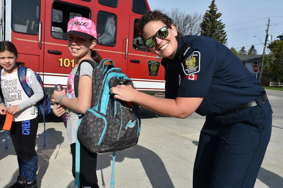 Bradford firefighter Nicole Higgins hands out ribbons to walkers, cyclists and other ‘rollers’ at Fred C. Cook Public School on Walk ‘n' Wheel Wednesday. Miriam King/Bradford Today