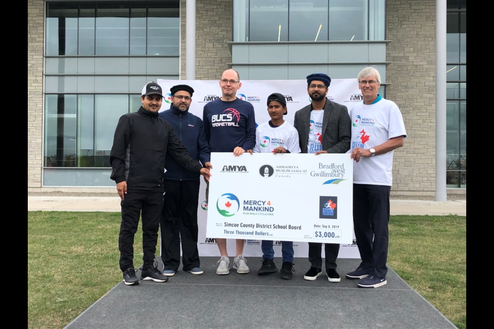 Members of the Ahmadiyya Muslim Community present a $3,000 cheque for Simcoe County District School Board.