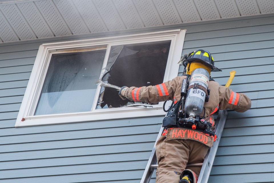 A firefighter smashes a window at a structure fire March 20. Submitted photo/Paul Novosad 