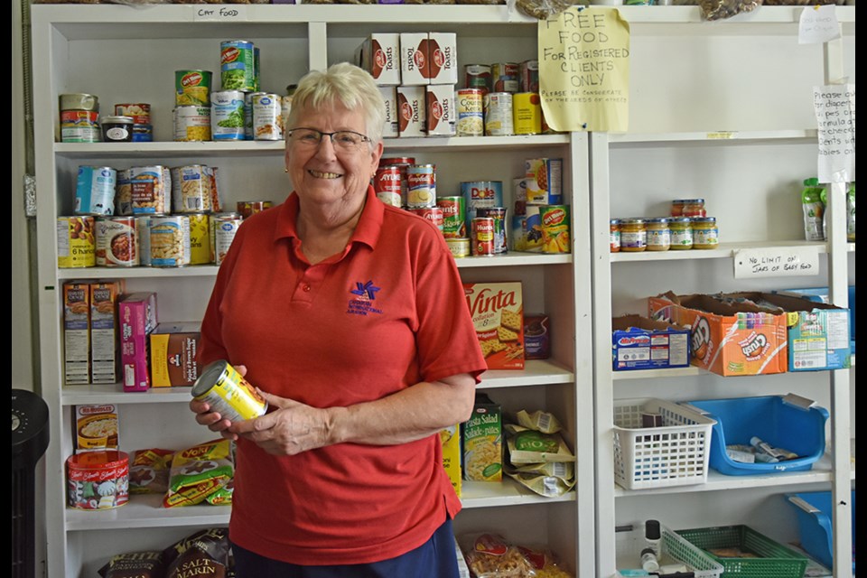 Anne Silvey, volunteer president of the Helping Hand Food Bank in Bradford, checks the best-before date on a can, before setting it on the free shelf at the food bank. Miriam King/BradfordToday