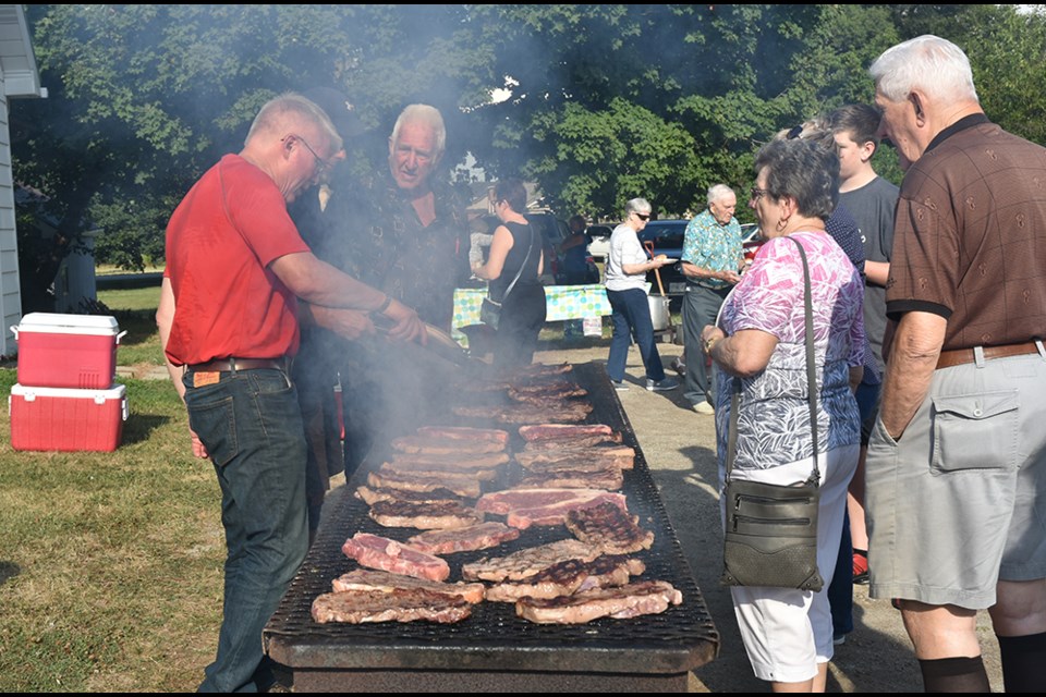 Hungry guests line up to choose their steak - rare, medium or well-done - grilled by volunteers. Miriam King/Bradford Today