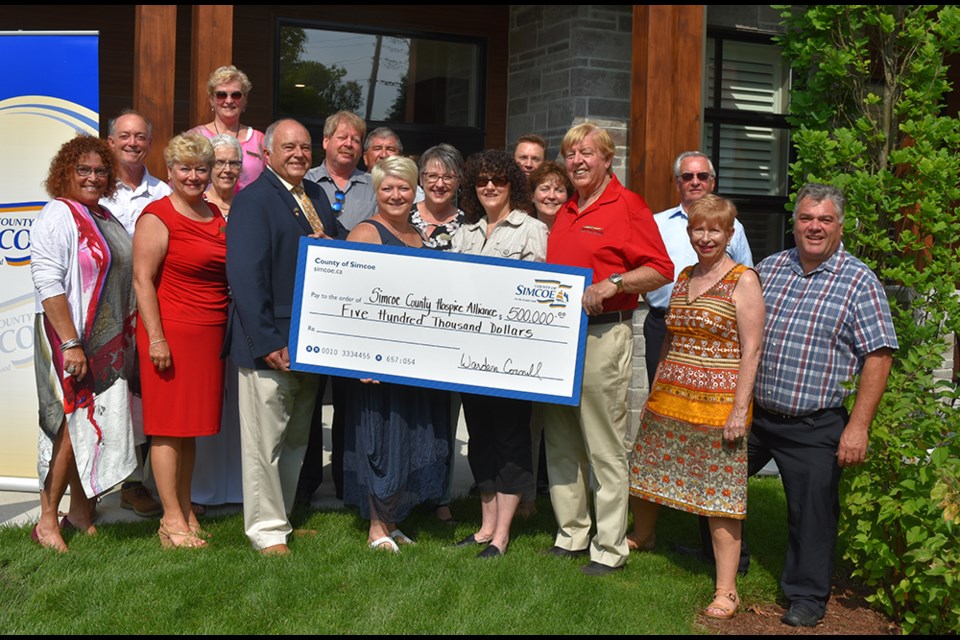 Simcoe County Warden George Cornell presents funding to the Simcoe County Hospice Alliance, and representatives of five hospices and their host municipalities. Miriam King/Bradford Today
