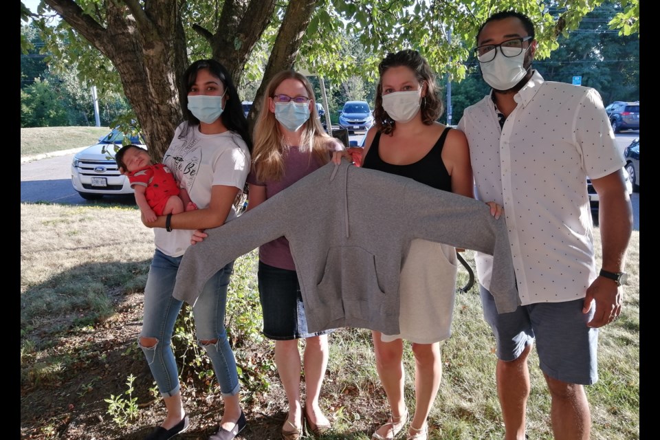 L-R Baby Elias, Pryanka Balley, Caroline Greason, Jessica and Rodrigo Silva. Jessica and Caroline are holding the sweater that Pryanka gave up for the baby to be wrapped in upon his birth. Supplied photo