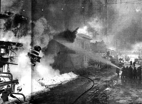 Photo showing firefighters battling the fire on Holland St West, in 1959. From the archives of the BWG Public Library. 
