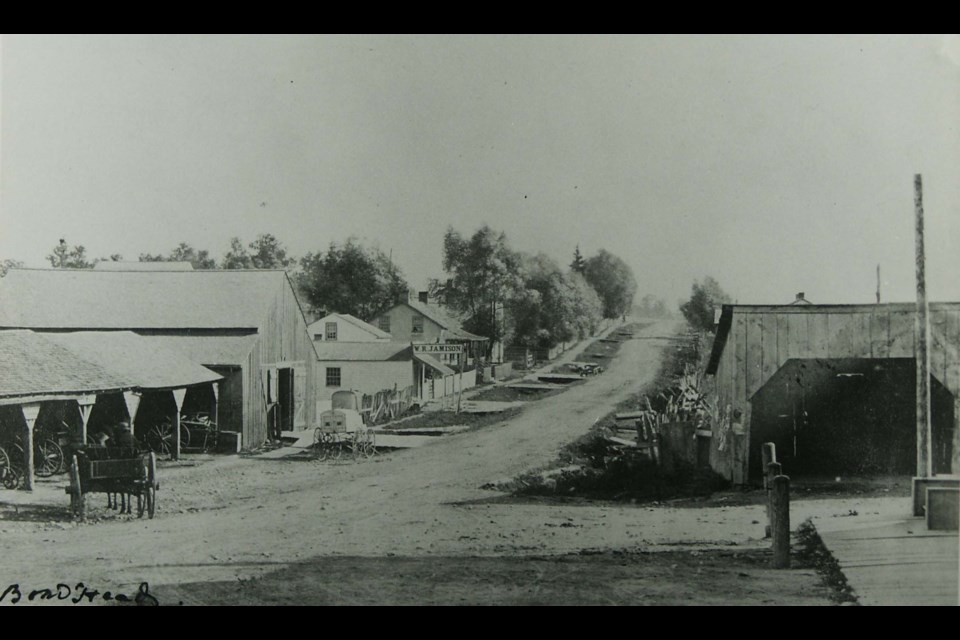 Bond Head looking south on Highway 27 from Highway 88 in 1867 or 1868. The image shows board sidewalks, looking south, which extended to the 6th Line. Note the boardwalk joining the road to the sidewalk. BWG Public Library Archives 