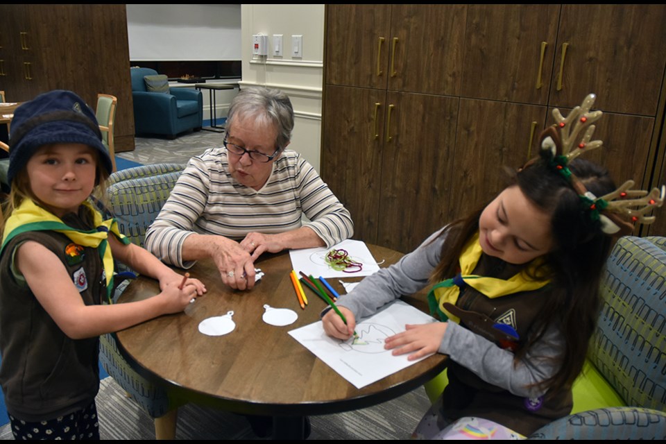 Resident Denise Marcil helps young Beavers decorate ornaments at The Elden retirement residence. Miriam King/Bradford Today