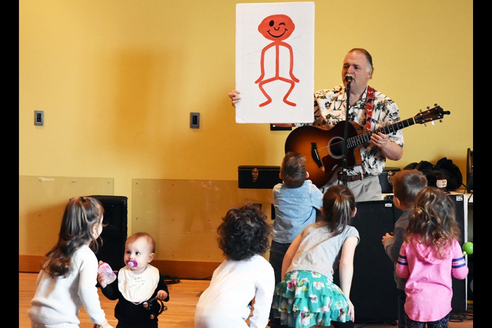 Kids match the pose of the stick figure held up by singer Russ Clayton, at the library. Miriam King/Bradford Today