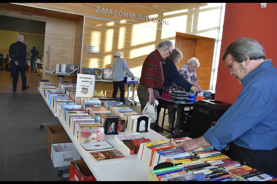 Families and individuals paid extra to be the first to check the volumes offered for sale, at the Friends of the Library Spring Book Sale. Miriam King/Bradford Today