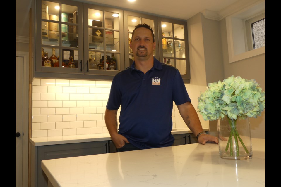 Jason Farrugia, standing in a basement bar area he built himself, started Handy Neighbour for Hire nearly four years ago.  Jenni Dunning/BradfordToday