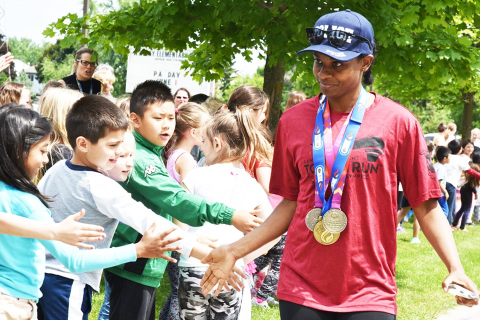 Special Olympian Monique Shah high-fives students June 7 during the torch run. Miriam King/Bradford Today