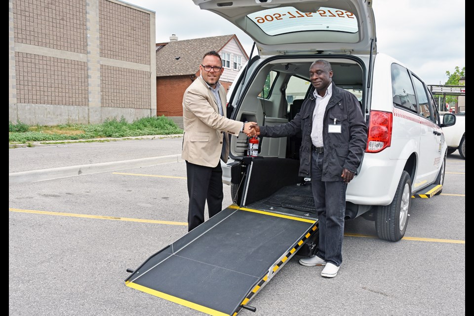 BB Taxi owner Addai Sarfo, known to his clients as Kasy, right, thanks Frank Caietta of Vaughan Chrysler, in front of a new accessible taxi. | Miriam King/BradfordToday file