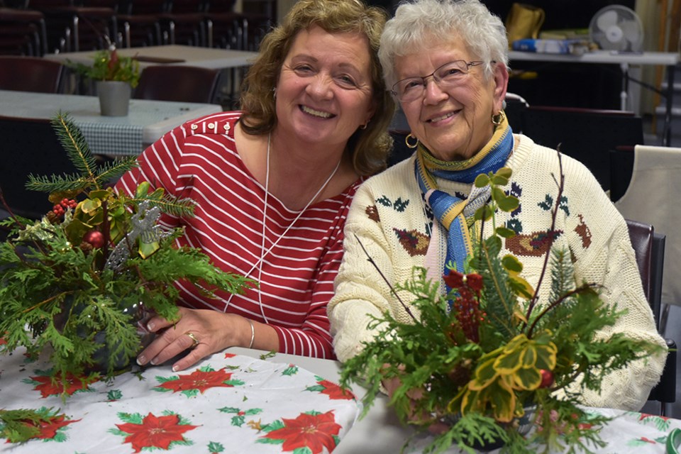 Cathy Howe, left, and Olga Bishop have fun at the Christmas centrepiece workshop, at the Bond Head-Bradford Garden Club. Miriam King/BradfordToday