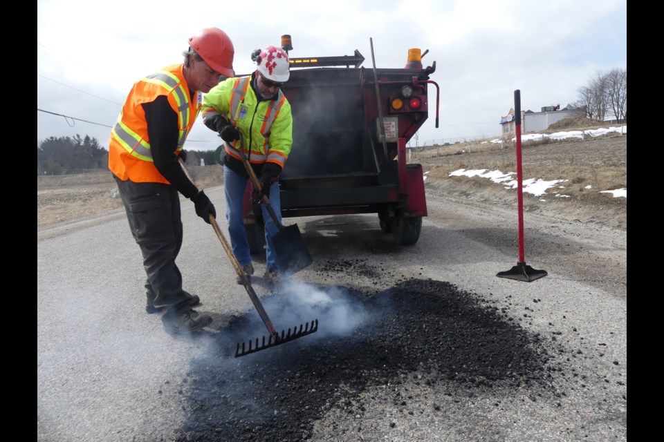 Mike Oliver, left, and Carlos Faria fill a pothole in Bradford West Gwillimbury. Jenni Dunning/BradfordToday