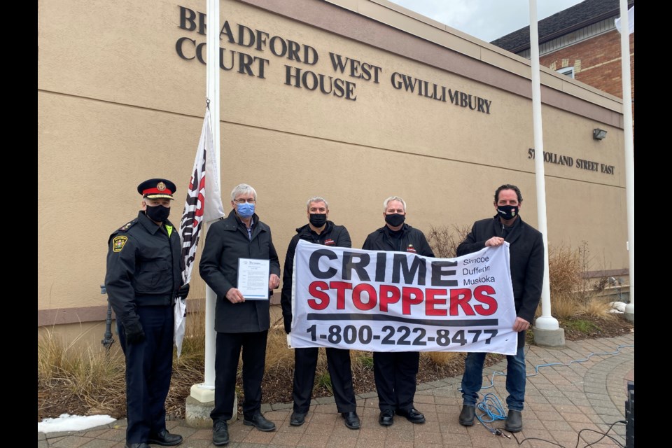 Mayor Rob Keffer, York-Simcoe MP Scot Davidson, South Simcoe Police Chief Andrew Fletcher and Crime Stoppers Simcoe-Dufferin-Muskoka Chair Dave Cockburn and Secretary Derek Adhiya helped raise the Crime Stoppers flag in front of the Bradford Courthouse.