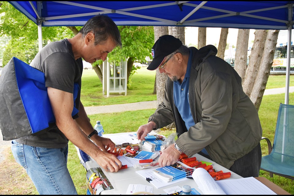 Eric Prentice, right, of the Barrie Power and Sail Squadron, sorts through expired distress flares brought in by boater Grant Bykowy. Miriam King/Bradford Today
