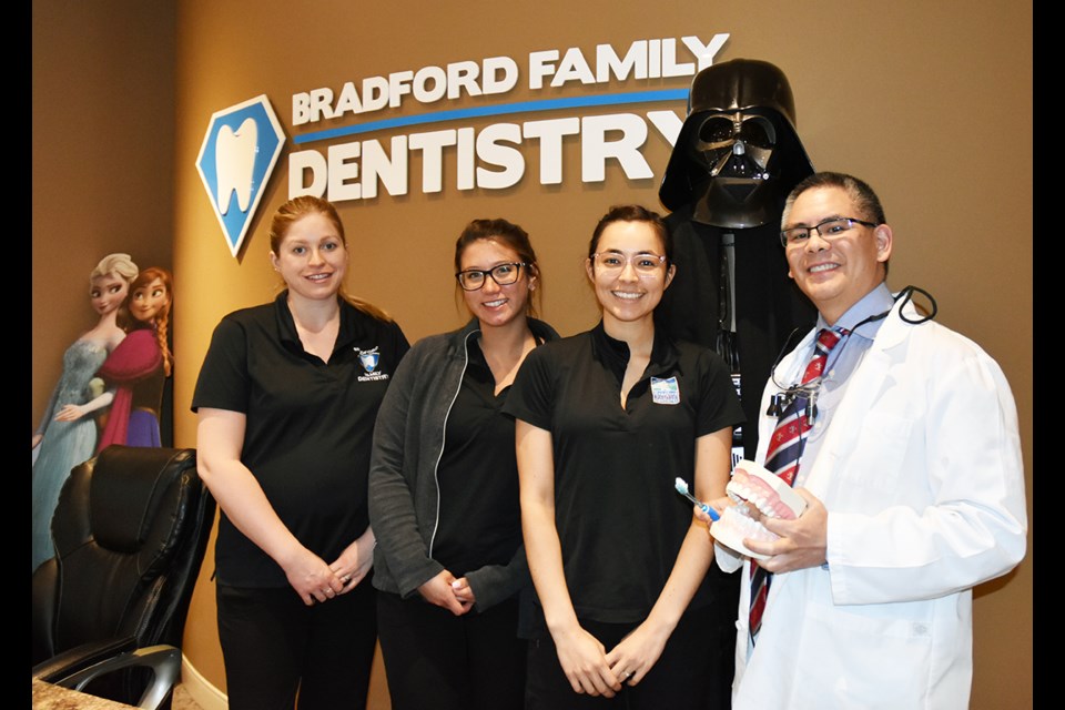 Bradford Family Dentistry staff members Sarah Preston, from left, Erica Garcia and Laurissa Lovic, and Dr. Jesse Chai (with a life-sized Darth Vader) at Bradford Family Dentistry. Miriam King/Bradford Today