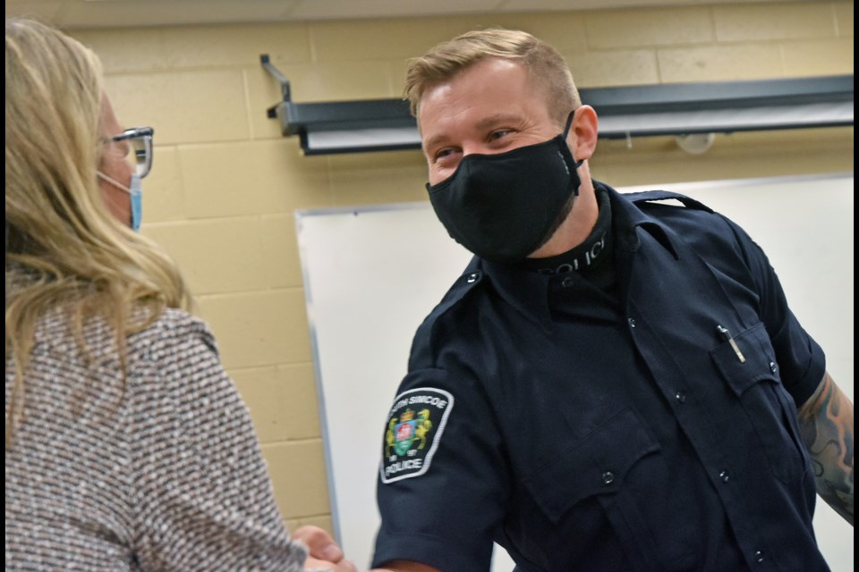 New South Simcoe police Const. Nick Manouris is congratulated by Innisfil Mayor Lynn Dollin. 