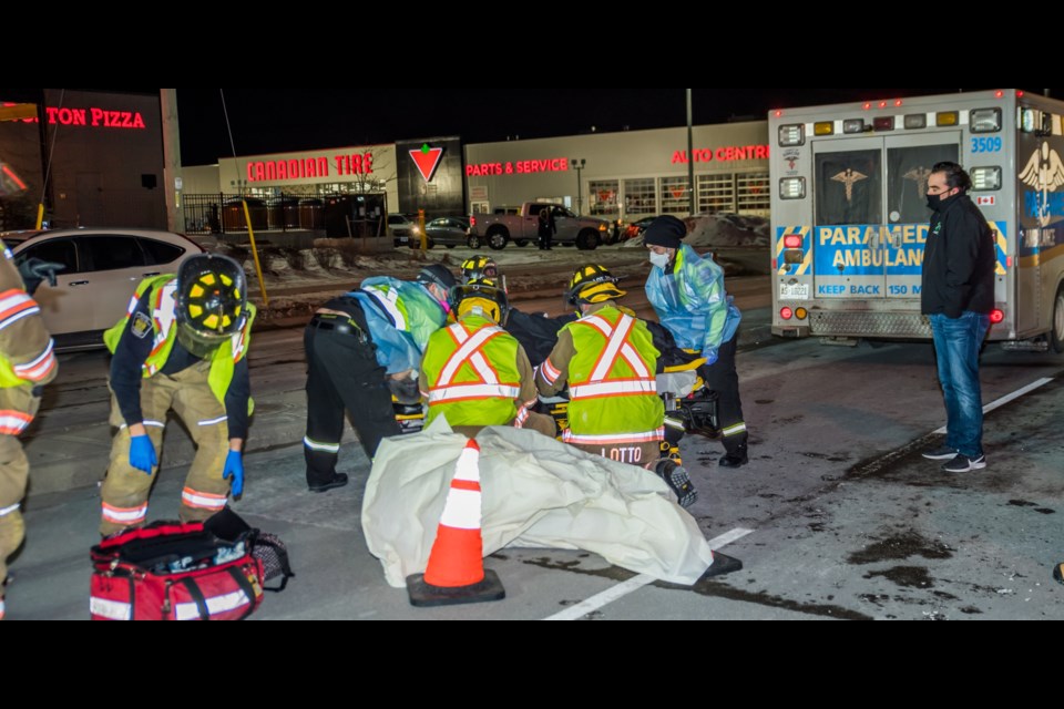 First responders attend to a woman who, witnesses say, was struck by two vehicles that fled the scene.