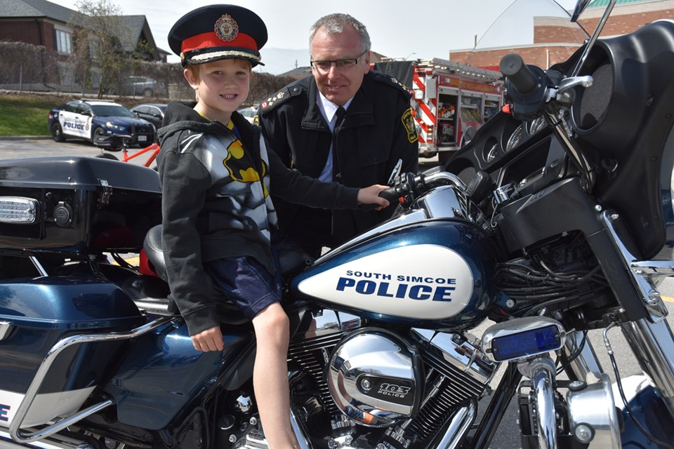 South Simcoe Police Chief Andrew Fletcher invites Chase, 5, to try out the police motorcycle – and the Police Chief’s hat - during a Police Week open house. Miriam King/Bradford Today