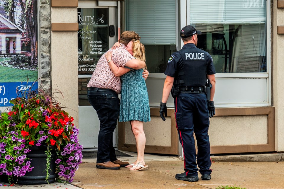 Peter Dykie's son, Justin, and a long-time employee share an emotional hug outside the store Thursday afternoon. Three people attempted to rob the store, Justin told BradfordToday.