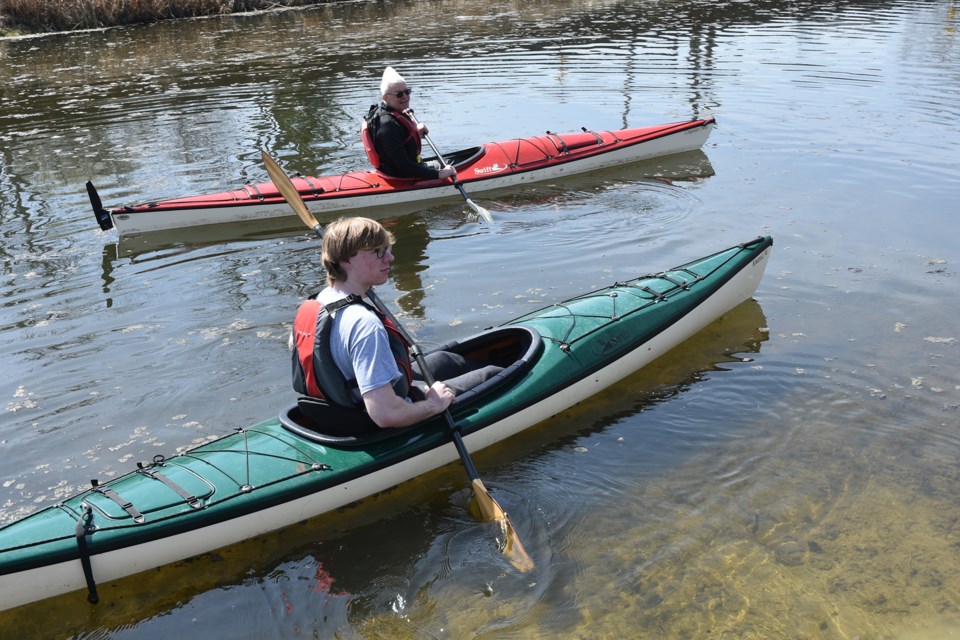 Kayakers Steve Quattrin (red boat), and Evan Welburn, grandson of race organizer Iain Craig, paddle the Holland Marsh  canal.